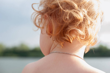 s red curls on the background of the river