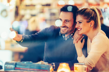 浪漫的年轻夫妇晚上在酒吧约会照片