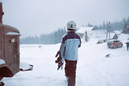 雪山上有滑雪板的年轻人