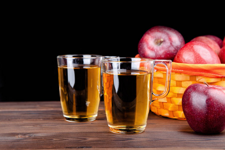 黑色背景下的两杯果汁和苹果
