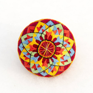 球的手鞠躺在雪地上的温特在明亮的帧中的米色背景上的白色雪花莲花束