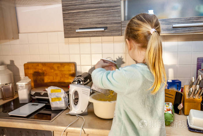 小女孩在厨房烤华夫饼后智能手机的食谱