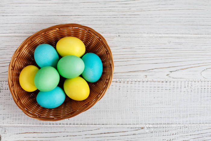 篮子里有彩色鸡蛋。顶部视图。概念复活节快乐