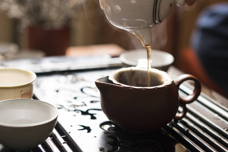 在中国传统茶道中浇上茶壶的精致热茶。成套设备