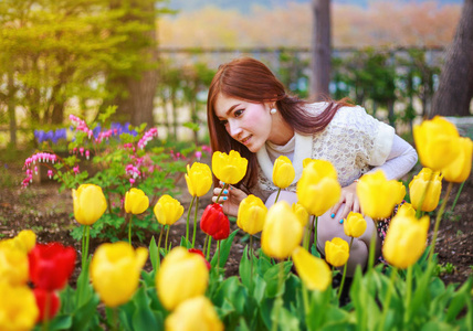 花园里有郁金香花的美丽女人