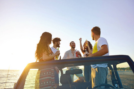 一群快乐的朋友在车上开派对年轻人喝香槟很开心