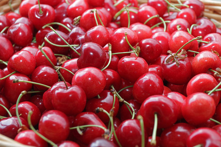 樱桃。 樱桃。 有机樱桃在农贸市场的篮子里。 红色樱桃背景。 新鲜樱桃的质地。 健康的食物概念。
