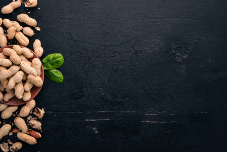 免费花生黑色木制背景上的花生. 健康的零食. 上面的风景.