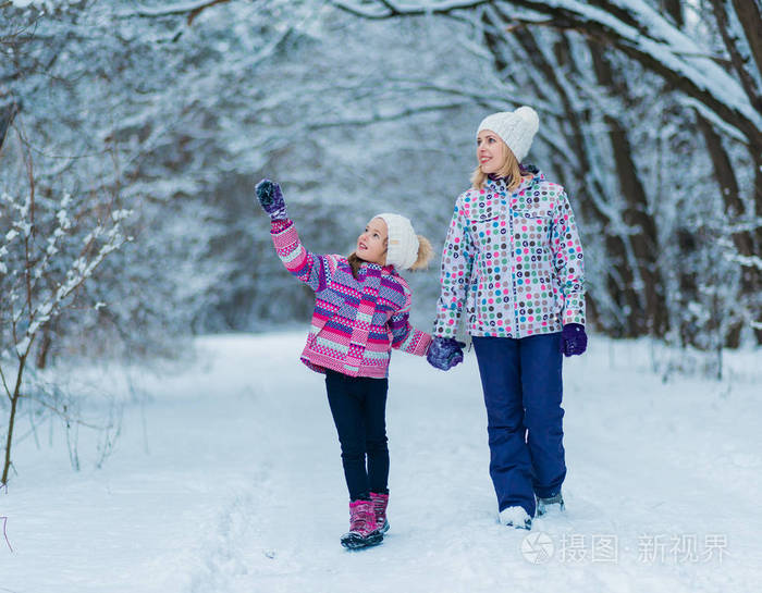 家庭有乐趣演奏和笑在下雪的冬天漫步在自然