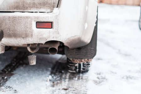 汽车在冬天, 后保险杠, 排气管与水桶和车轮上的刺。冬季轮胎在城市在停车场