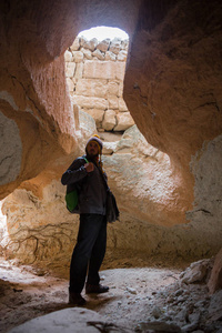 Glyufrafoss 瀑布在山的峡谷。旅游胜地冰岛。男子游客穿着蓝色夹克站在一块石头上, 看着水流的下落。自然美