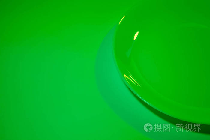 由两盏紫外线灯点亮的简单陶瓷白色盘子的抽象图片。 充满活力的绿色。