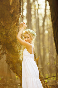 金发女郎站在白色的礼服树上