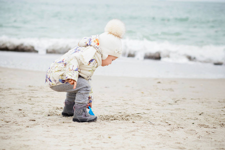 可爱的小女孩在沙滩上玩耍。快乐的孩子穿