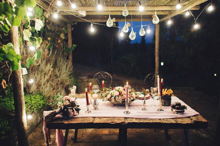 装饰的户外婚礼桌上有乡村风格的花灯和蜡烛