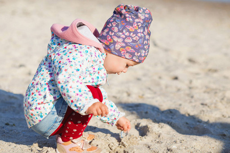 可爱的小女孩在沙滩上玩耍。快乐的孩子穿