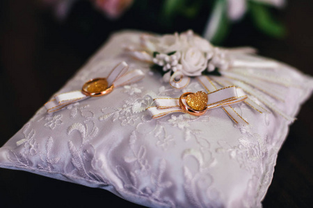金色婚纱戒指在白色美丽的枕头上