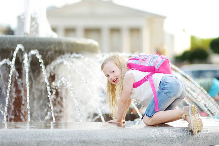 可爱的小女孩在炎热和阳光明媚的夏天在城市喷泉边玩孩子们在夏天玩水