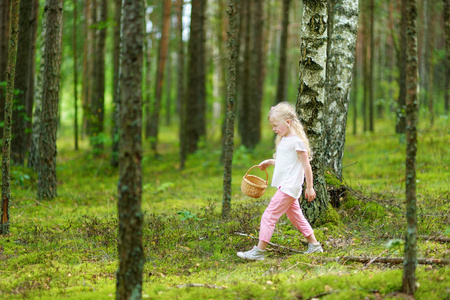 可爱的小女孩在美丽的夏日森林徒步旅行中玩得很开心。 积极的家庭休闲与孩子。