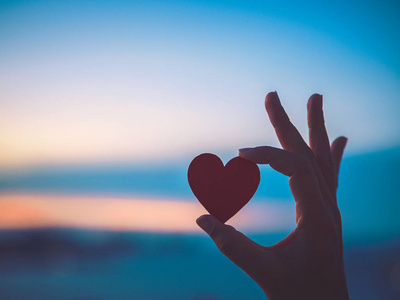 股票形象靠近女人和女孩的手,牵着心双手呈爱心形状情侣相爱,在度假