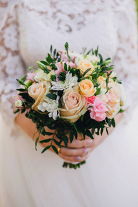 美丽的婚礼花束与黄色玫瑰, 白色菊花和粉红色 Alstroemeria 在手