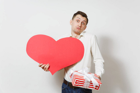 不满意的男子在衬衫持有大红色的心, 礼物盒与礼品隔离白色背景。广告的复制空间。St. 情人节, 国际妇女节生日假期概念