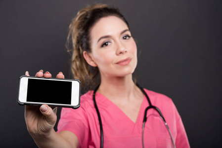 女性医生持有黑屏智能手机的选择性聚焦