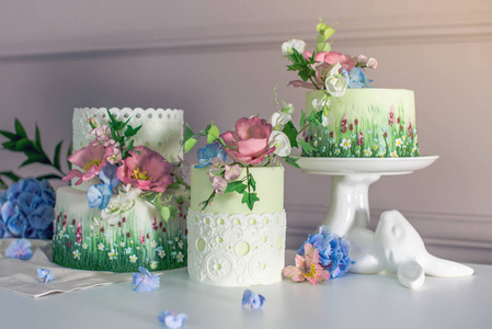 婚礼春天蛋糕装饰着五颜六色的花朵和绣球。节日夏日甜点