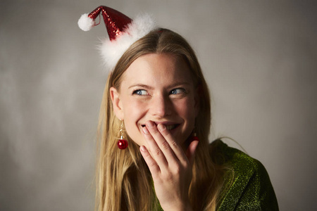 戴着圣诞帽的年轻女子傻笑着看着照片
