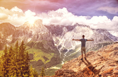 站在山顶上的人举起双手站在阴云密布的山谷之上照片