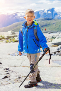 徒步旅行的装备在山上的可爱男孩