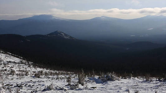 冬季山脉的场景, 太阳云和阴影上空的积雪景观。视频.雪山和阳光普照。山边和山脊覆盖着新鲜的粉雪
