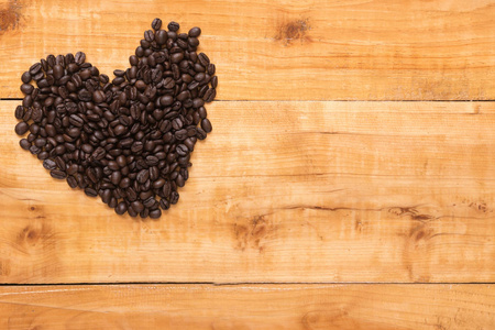 咖啡豆的心在棕色木桌上, 顶角视图, 复制空间