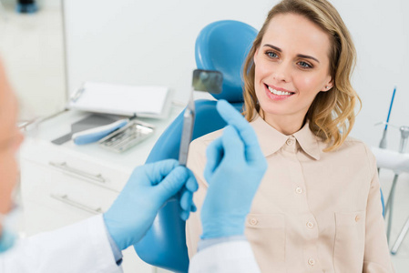 现代牙科诊所显示女性病人X光的牙医