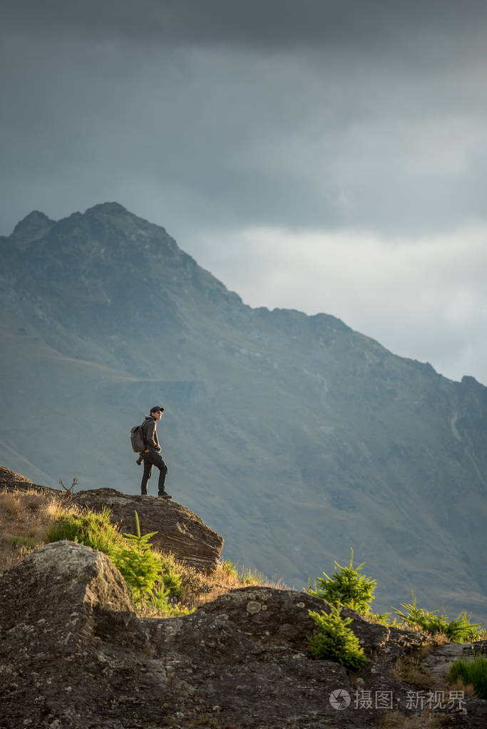 在皇后镇看风景的年轻男性摄影师