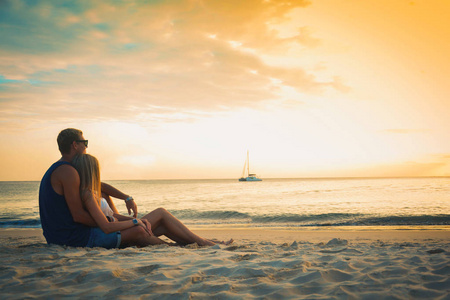 海滩上的情侣在日落的暑假, 美丽的年轻人在恋爱中, 男人女人牵手海洋假期旅行