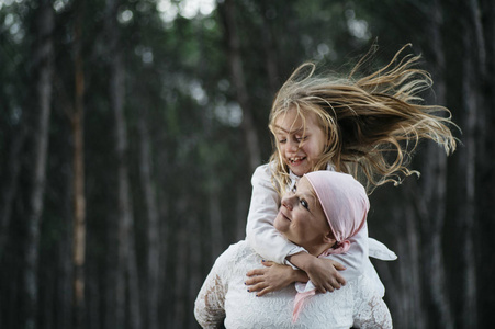 一个患癌症的妇女挨着她的女儿。一个女孩在拥抱