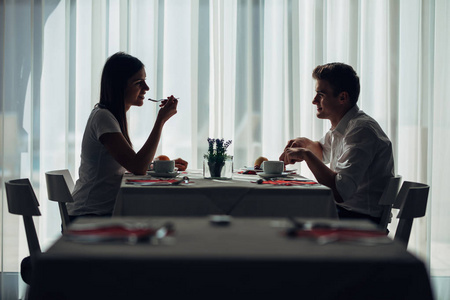 两个随意的年轻人在吃饭时交谈.在餐馆里正式的求婚.