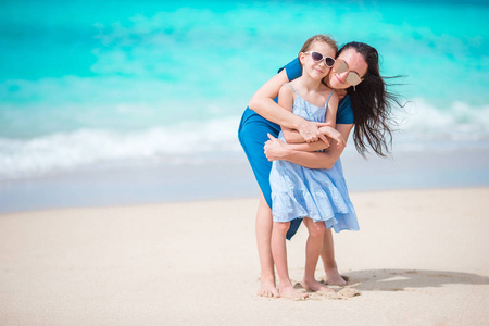 在白色沙滩上的家庭乐趣。母亲和小孩享受暑假