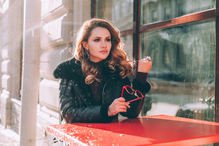 悲伤的女人在街上的咖啡馆里等待.女孩孤独照片