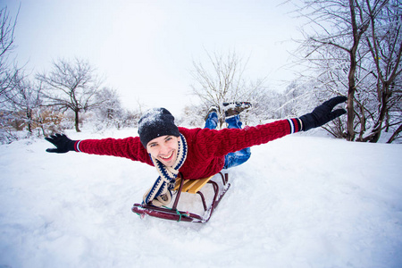 疯子喜欢坐雪橇。 男人雪橇。 有趣的人在雪地里户外玩耍。 冬天，人们在阿尔卑斯山的山上雪橇。 圣诞节假期的户外乐趣。