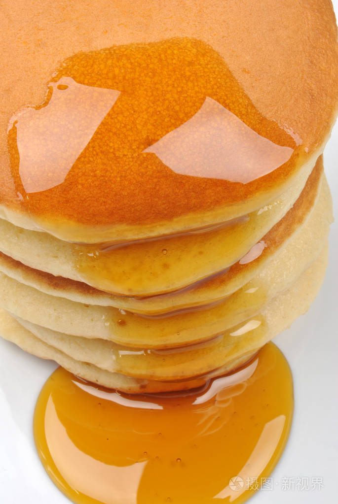 在白色盘子里放上蜂蜜的自制薄饼