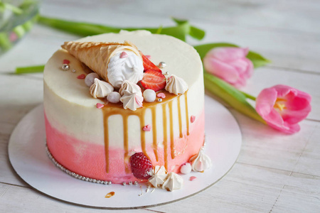 白色的木桌上的节日蛋糕。粉色和白色的颜色。Bi