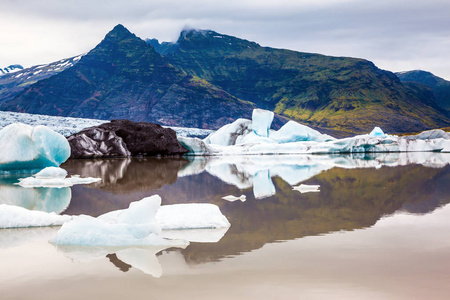 阴天时冰泻湖浮冰并反射在光滑水面..北方极端旅游的概念