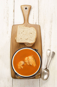 鲤鱼汤用木板上的面包做的匈牙利鱼汤照片