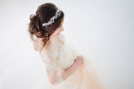 美丽的女孩跳舞穿婚纱的样子。在白色背景上的豪华礼服的新娘