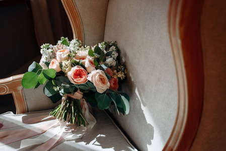 婚礼花束与白色花, 玫瑰, 绿色和丝带在椅子上