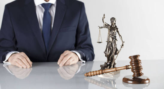 法律顾问。 木槌和他们的雕像在白色的桌子和背景上。