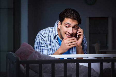 快乐的爸爸在夜里照看新生婴儿照片