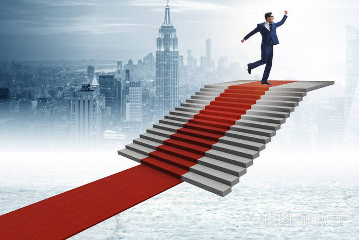 年轻生意人攀登台阶和红色地毯